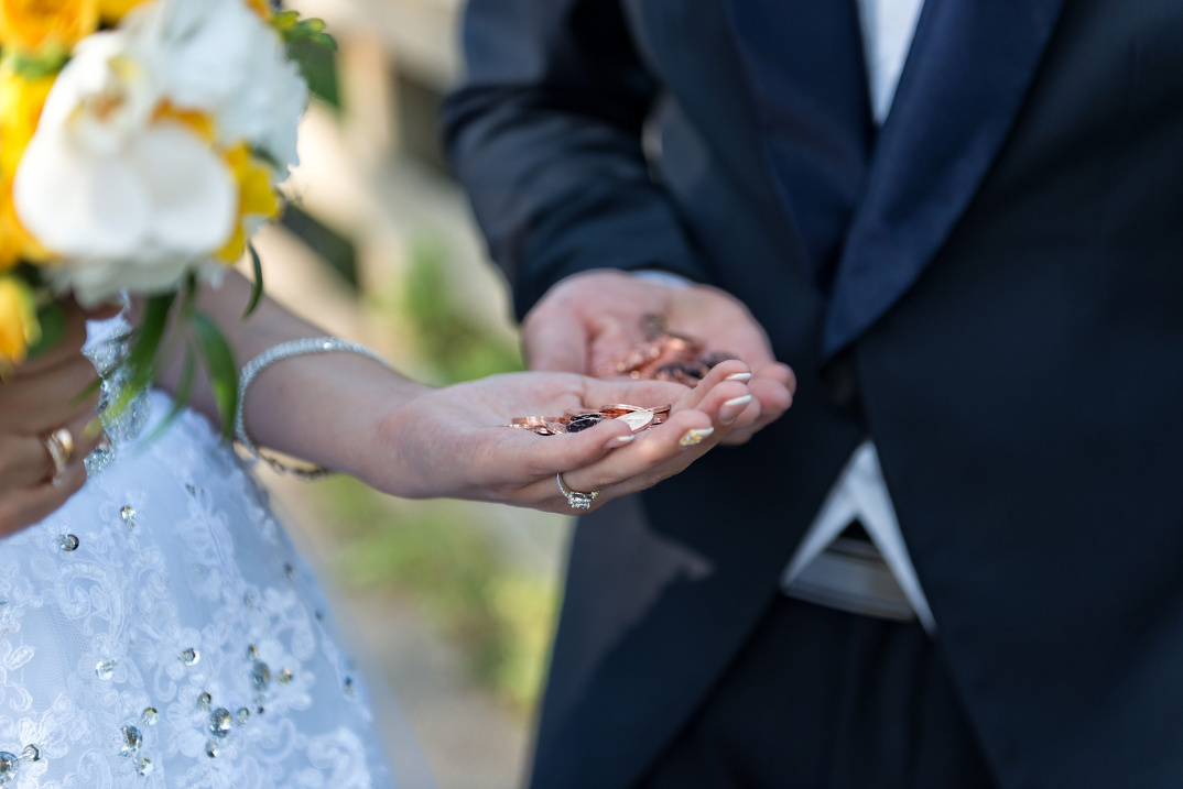 The bride and groom holding coins in their hands